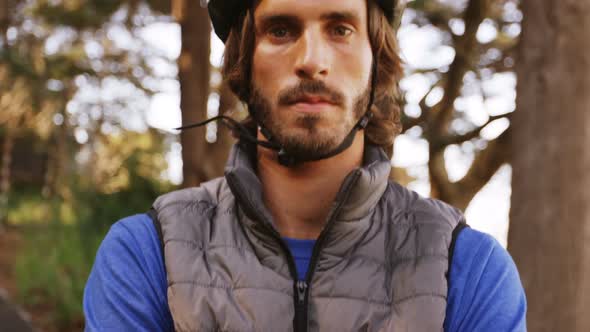 Portrait of mountain biker standing with arms crossed