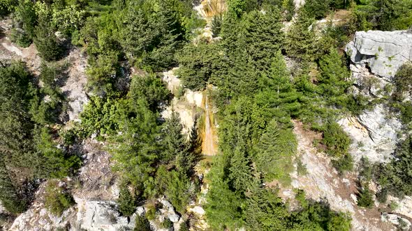 A small waterfall in the mountains aerial view 4 K