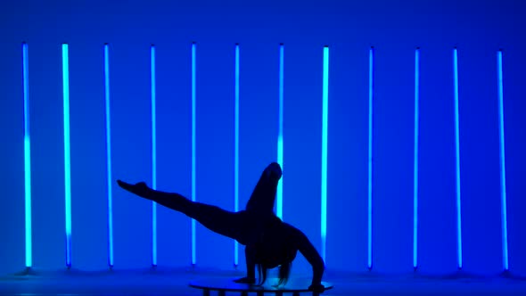 A Young Woman Performs a Handstand Moves Her Legs and Splits Them