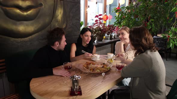 A Group of Friends Sit in a Restaurant and Chat