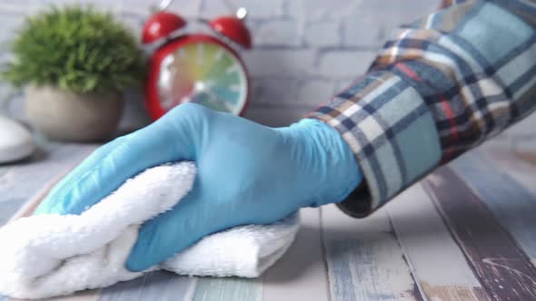Hand in Blue Rubber Gloves Cleaning Table with Cloth