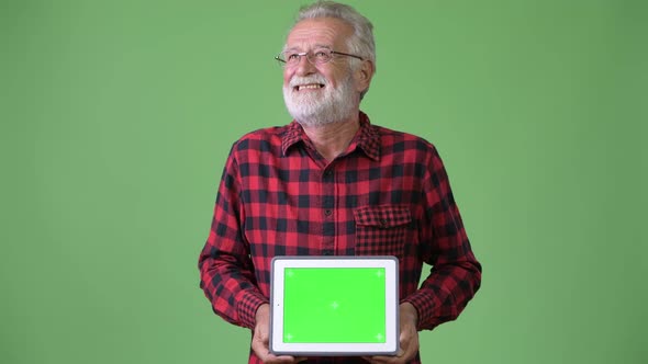 Handsome Senior Bearded Man Against Green Background