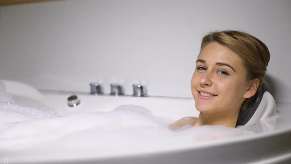 Smiling Woman Relaxing in Whirlpool and Looking at Camera, Spa Beauty Procedure