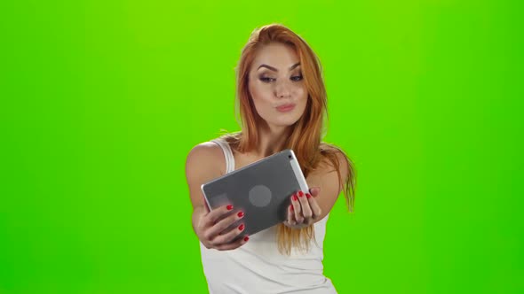 Redheaded Model Grimaces on Camera a Tablet