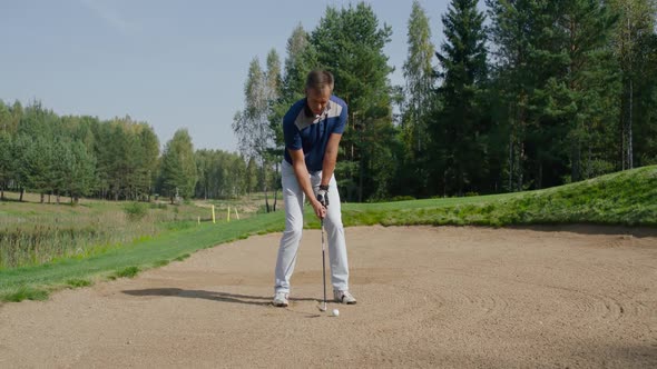 Summer Day Man Standing on the Sand and Playing Golf Hits the Ball View of Golf Course in Forest