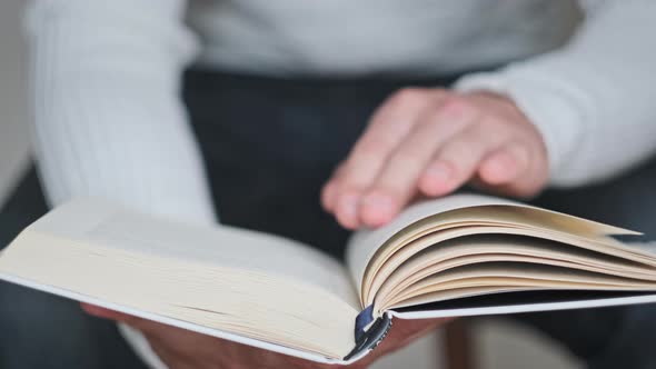 Young Man Reading a Book and Turning Pages Close Up Slow Motion