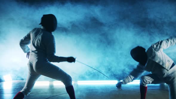 A Fencer is Getting Attacked By His Opponent and Falling on the Floor