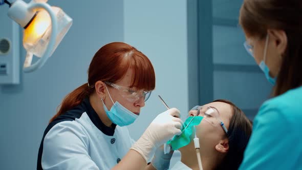 Dentist woman cures patient's tooth attentively