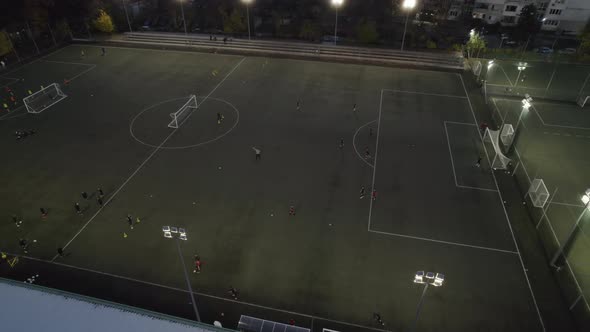 People Playing Soccer at Night on Sports Field in City Park