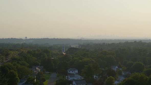 Rising Aerial from Neighborhood Amongst Trees to NYC Skyline from a Distance