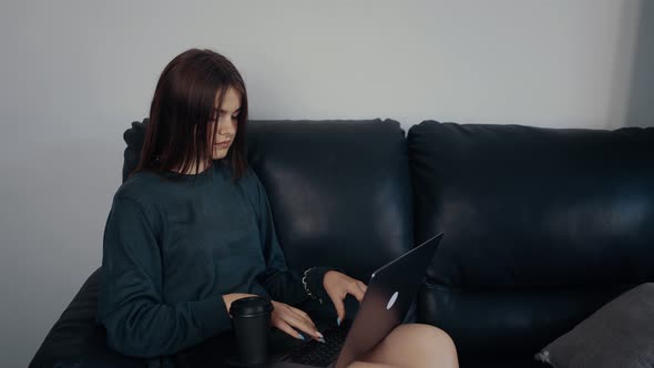 The Businesswoman Works at Home Online Sitting on the Couch She Looks Thoughtful and Focused on
