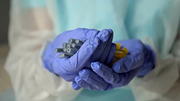 Hands of a Nurse in Protective Latex Gloves Hold Syringes Prepared for Vaccination