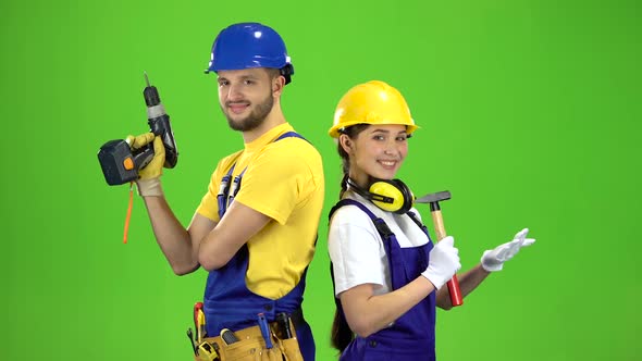 Builder Standing a Guy Holding a Drill, a Girl Hammer. Green Screen
