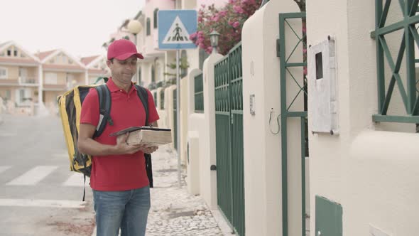 Courier in Uniform Ringing Doorbell, Giving Package To Customer