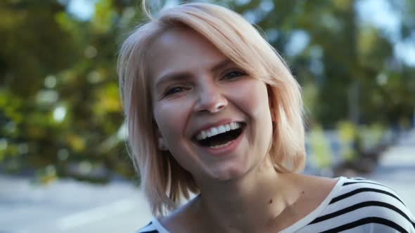 Happy Smiling Laughing Attractive Blonde Girl Having Fun in the City Street.