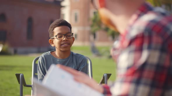 Close Up of Teacher Talking To African-American Boy Enjoying Outdoor Lesson