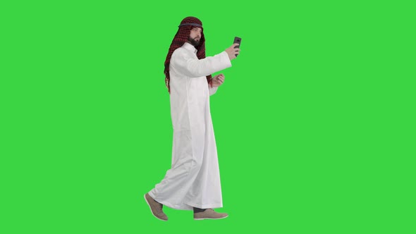 Arabian Man Walking and Making a Selfie with His Phone on a Green Screen Chroma Key