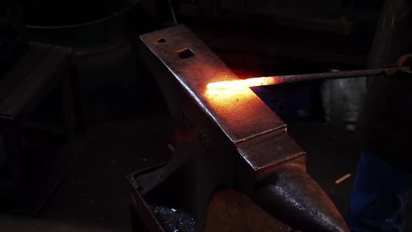 Mid-section of blacksmith working on a iron rod