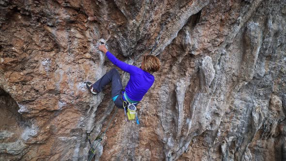 Slow Motion Woman Rock Climber on Overhanging Cliff