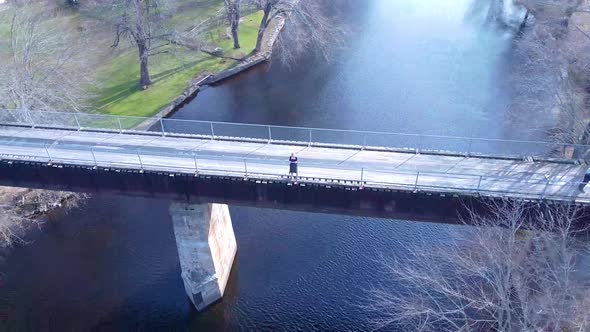 Aerial young women standing on a bridge over a river