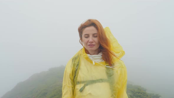 Portrait of a woman in a foggy weather looking into the camera.
