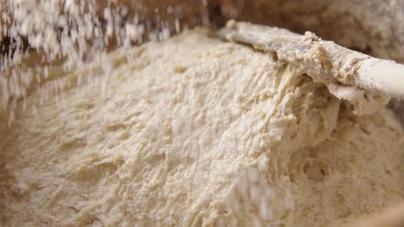 BAKING - Sprinkling a little flour during sourdough bread baking, slow motion