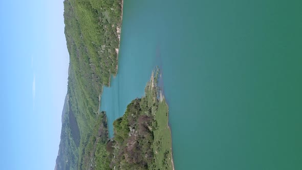 Scenic flyover above lake formed by Maneciu Dam in Romania. Vertical video