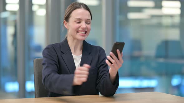 Successful Young Businesswoman Celebrating on Smartphone
