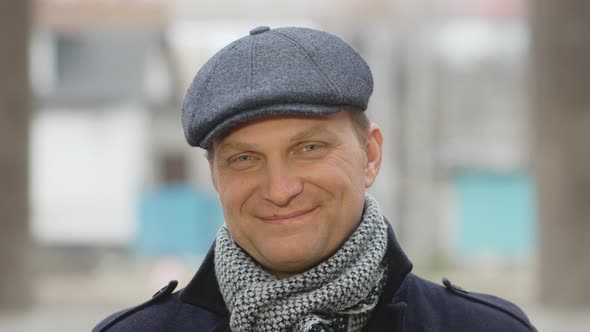 Portrait of a confident young man smiling at the camera. handsome man in a hat. Lifestyle concept