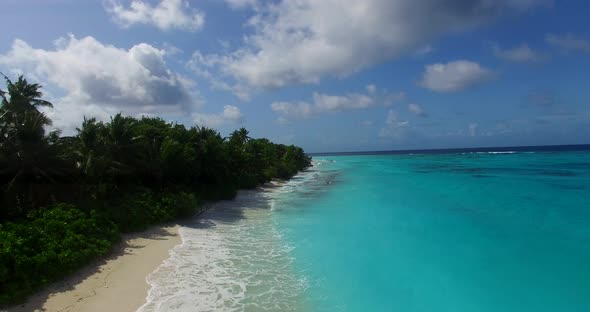 Wide drone island view of a white paradise beach and aqua turquoise water background in vibrant 4K