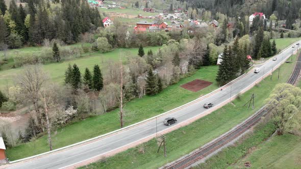 Speed highway in Carpathian mountains. Drone flying over car road surrounded by trees