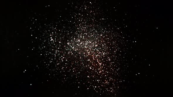 Red and Silver Glitter Explosion in Super Slow Motion on Black Background