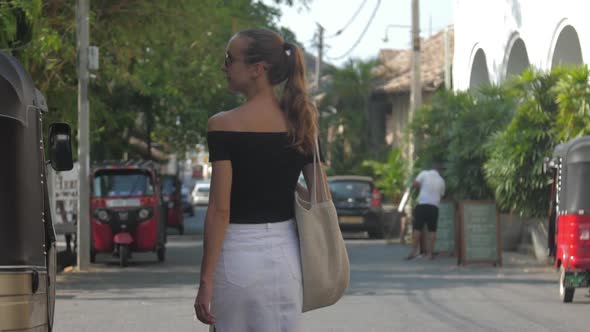 Woman Approaches Hotel Walking Past Local Mototaxi