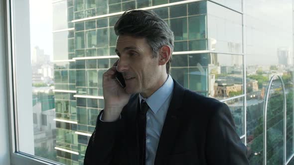 Businessman talking on smartphone in office