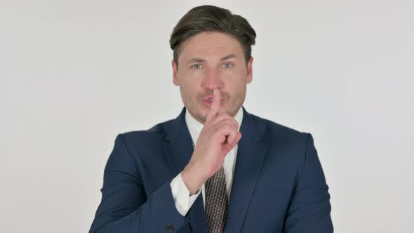 Middle Aged Businessman Putting Finger on Lips, Silence, White Background