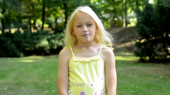 Little Cute Girl in Park Changing Different Face and Body Expressions