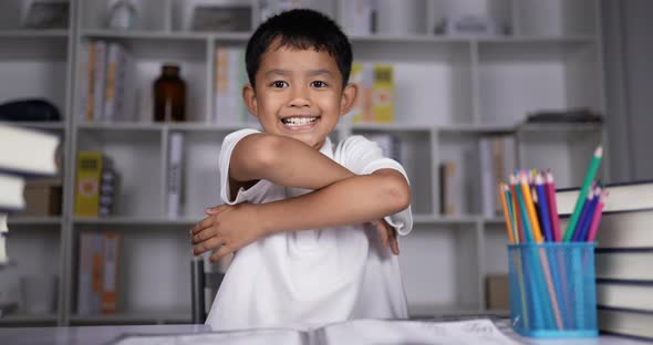 Boy waving hands gesturing hello or goodbye and arms crossed.