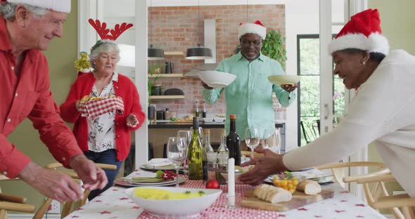 Happy group of diverse senior friends celebrating meal at christmas time