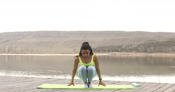 Athletic young woman standing in plank exercising.