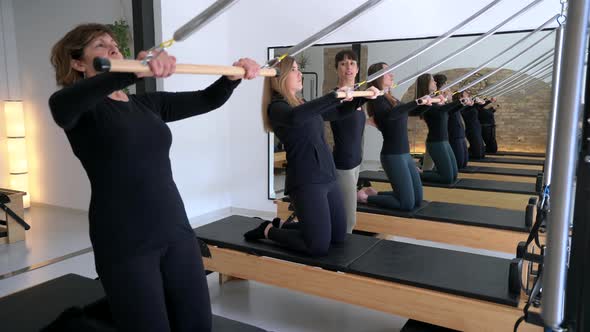 Women exercising on reformer during pilates workout