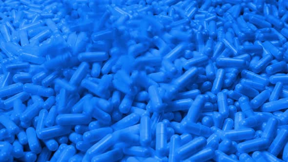 Pouring Blue Pharmaceutical Capsules Into Pile