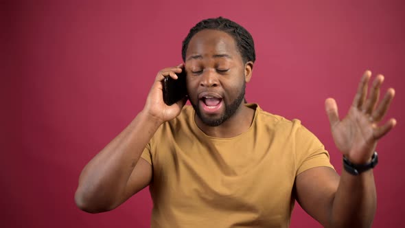 AfricanAmerican Guy Wearing Casual Tshirt Talking on the Smartphone