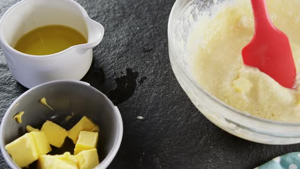 Woman adding butter cubes to batter in bowl 4k