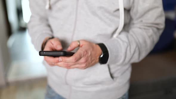 Man typing text, using online mobile application indoors, male enjoying communication