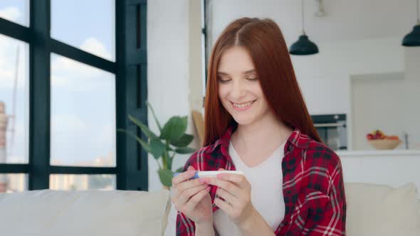 Happy Future Mother Pregnant Caucasian Girl Redhead Woman Looks at Positive Pregnancy Test Result