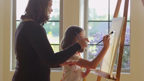 Woman and daughter painting together