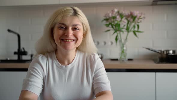 Portrait of a happy young adult Caucasian girl looking at camera and smiling at home indoors