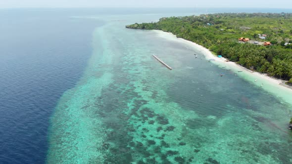 Aerial: Flying over tropical beach turquoise water coral reef, Indonesia 