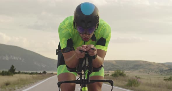 Closeup Shot of Triathlon Sportsman Athlete Cyclist Riding Professional Racing Bicycle