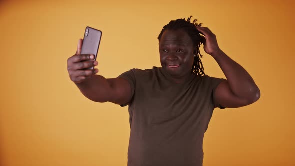 Young African American Black Man with Braided Hair Using Smartphone To Take Selfie.